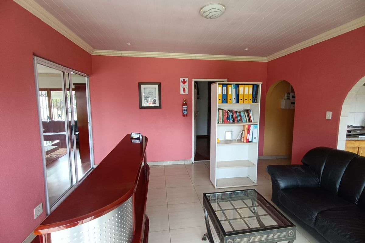 A living area featuring tiled flooring, arched doorways, and a reception-style counter, providing a functional space with potential for modernization.
