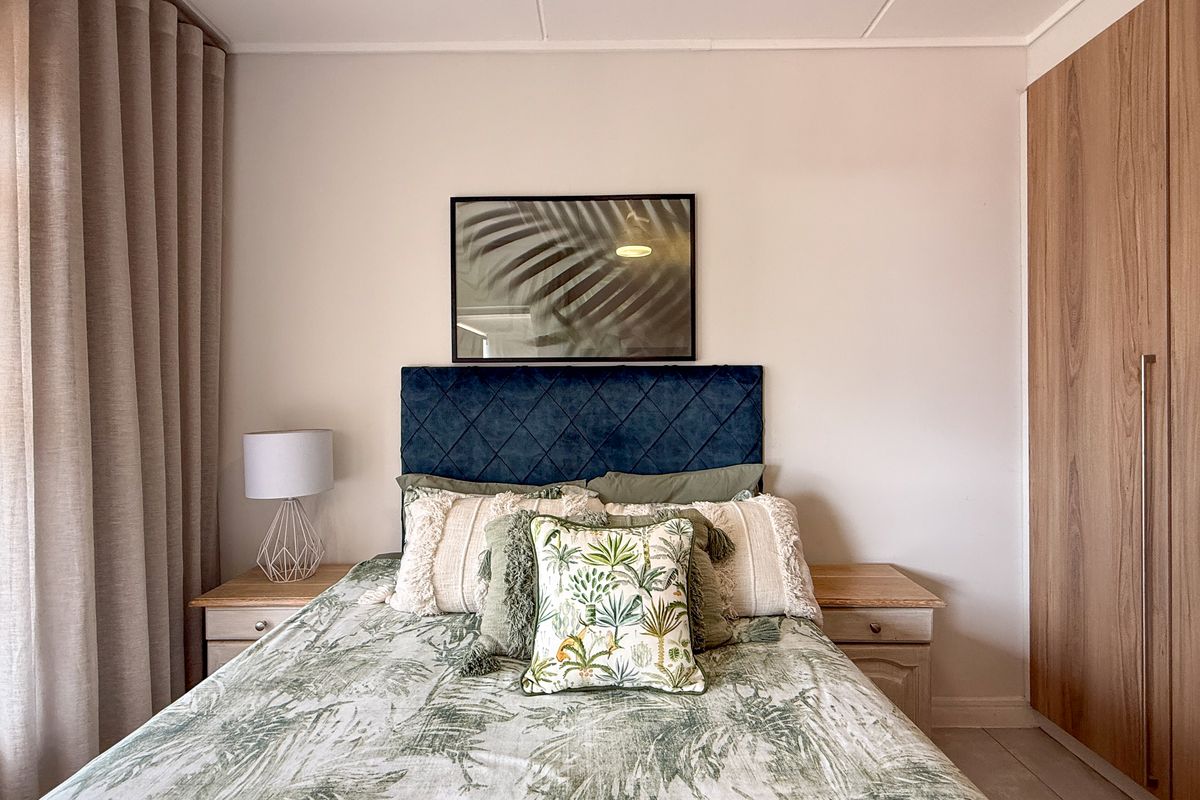 A well-maintained bedroom featuring built-in wooden cabinetry and neutral finishes, providing a clean and functional living space.