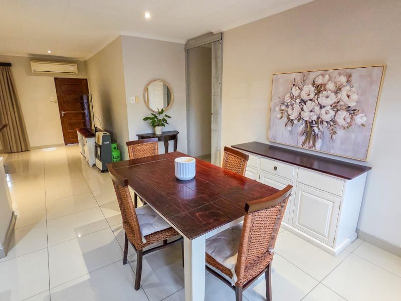 A bright dining area featuring tiled flooring, recessed lighting, and an integrated air conditioning unit, providing a comfortable space for meals.