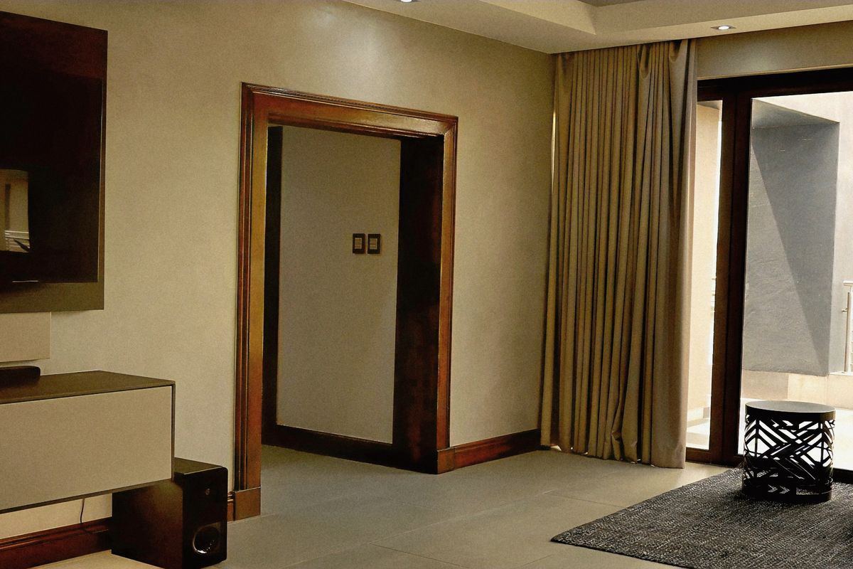 Modern living room featuring tiled flooring, recessed lighting, and large sliding glass doors providing access to an outdoor area.