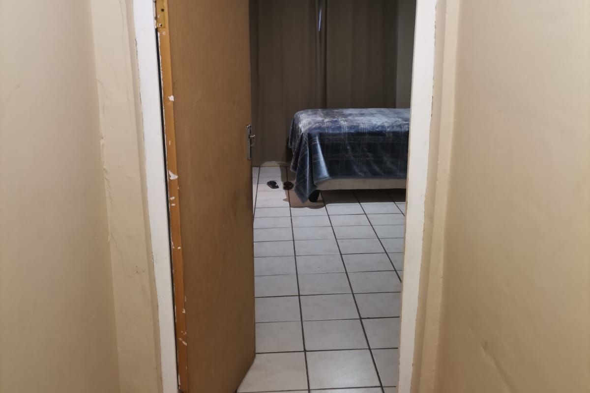A view through a doorway into a bedroom featuring tiled flooring and neutral wall finishes.
