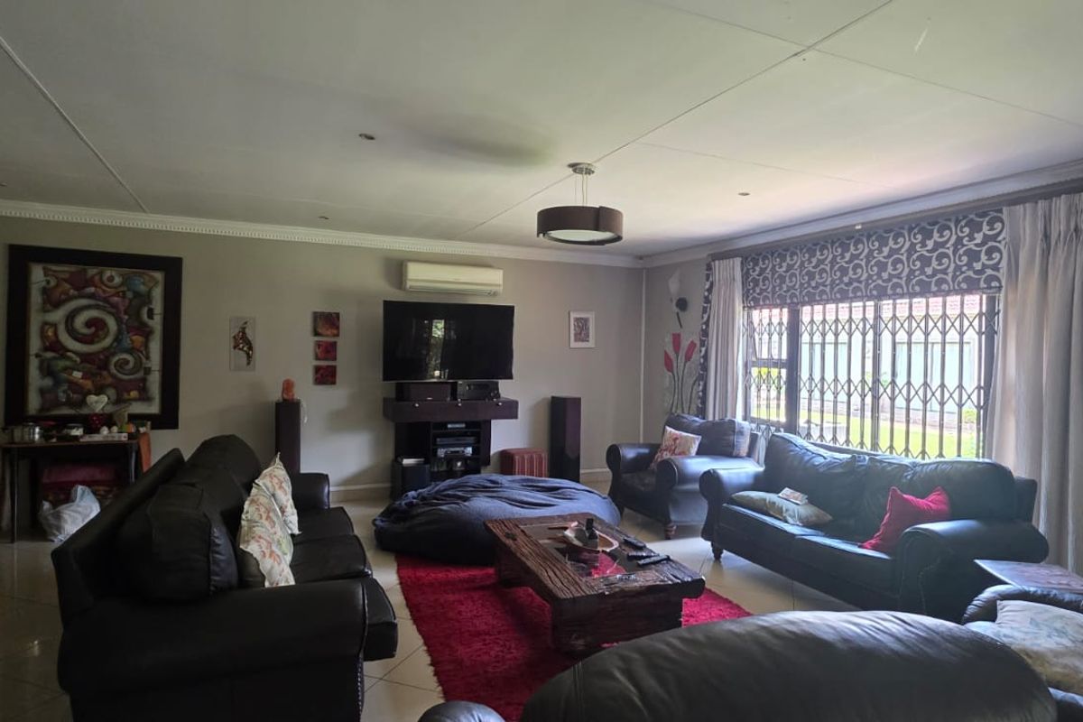 Spacious living room featuring tiled flooring, recessed ceiling lighting, and a wall-mounted air conditioning unit.