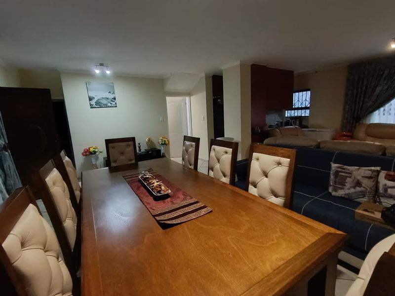 Open plan dining and living area featuring tiled flooring and neutral wall finishes, providing a functional space for family gatherings.