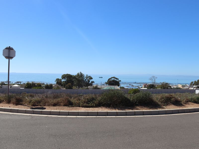 A clear view of the ocean and coastline from the street level of the vacant residential property.