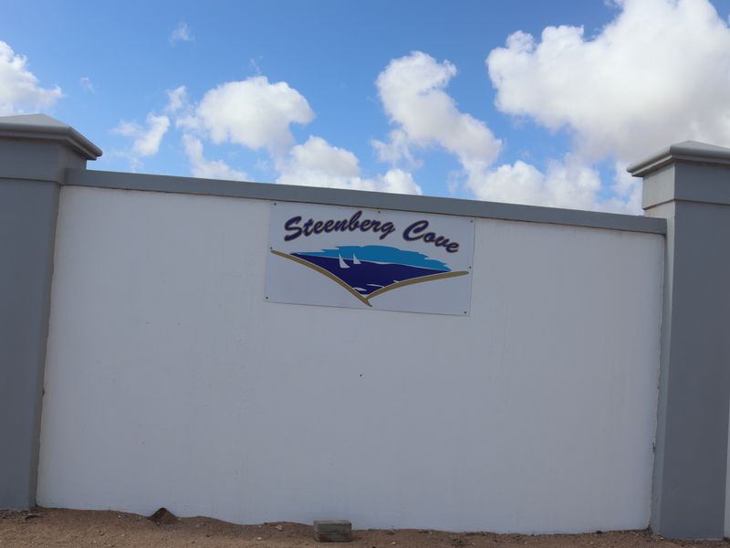 A view of the Steenberg Cove boundary wall and entrance signage, featuring solid masonry construction and pillars.