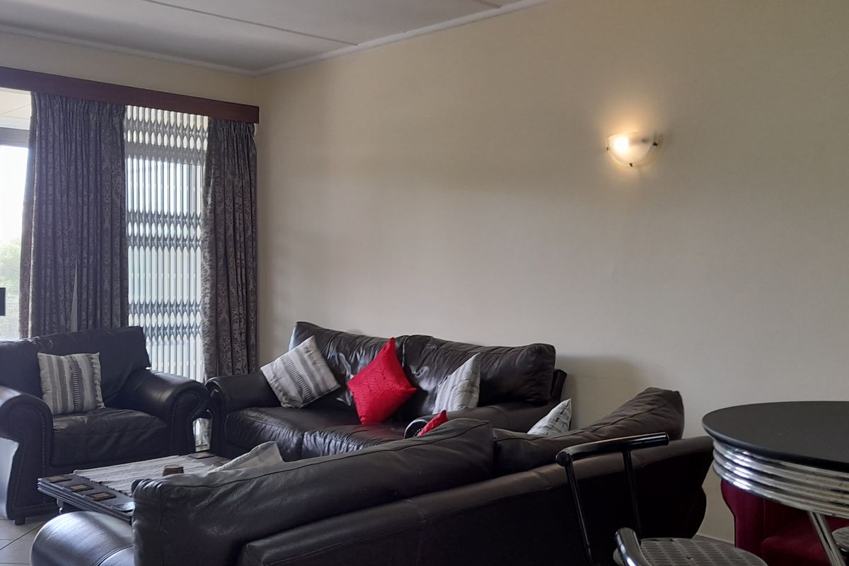 Spacious living area featuring tiled flooring and a large sliding glass door providing access to an outdoor balcony.