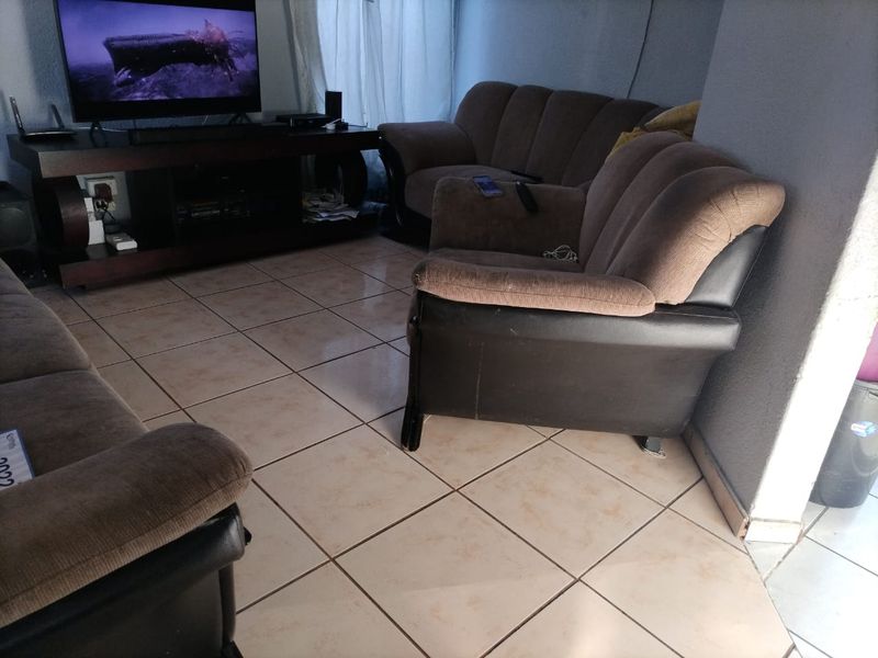 A living room area featuring ceramic floor tiles and neutral wall finishes, providing a functional space for relaxation.