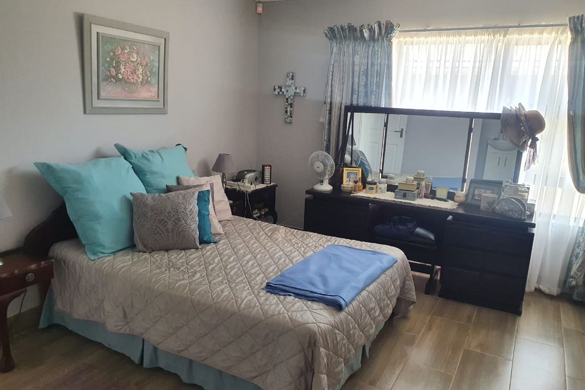 A bedroom featuring tiled flooring and cove cornice detailing, providing a functional and neutral space.