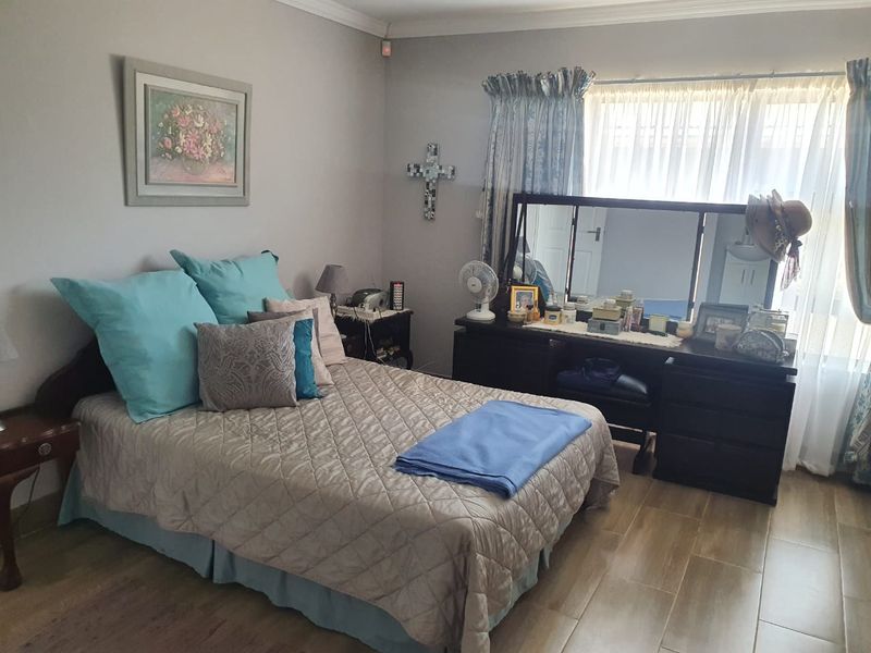 A bedroom featuring tiled flooring and cove cornice detailing, providing a functional and neutral space.