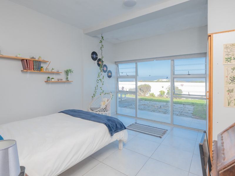 Bright bedroom featuring large sliding glass doors that provide natural light and direct access to the outdoor patio area.
