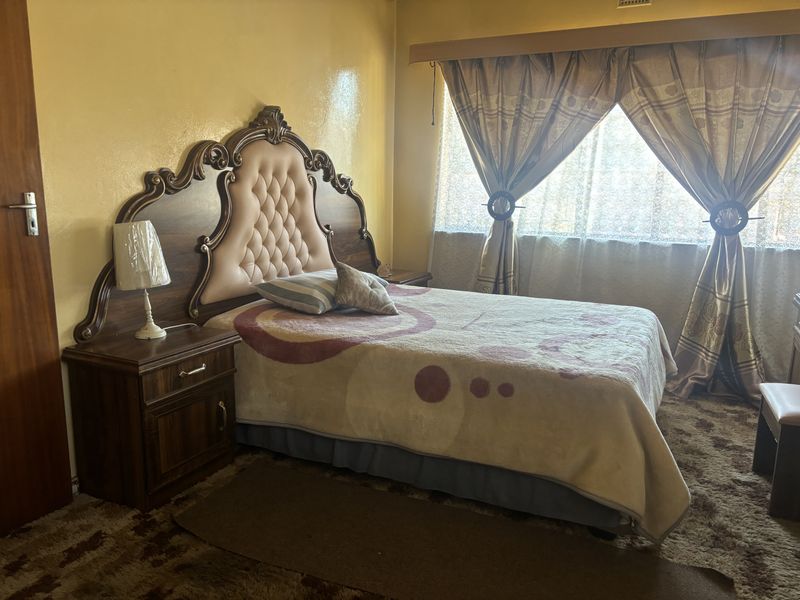 A bedroom featuring dated carpet flooring and yellow wall finishes, offering potential for modernization and aesthetic updates.
