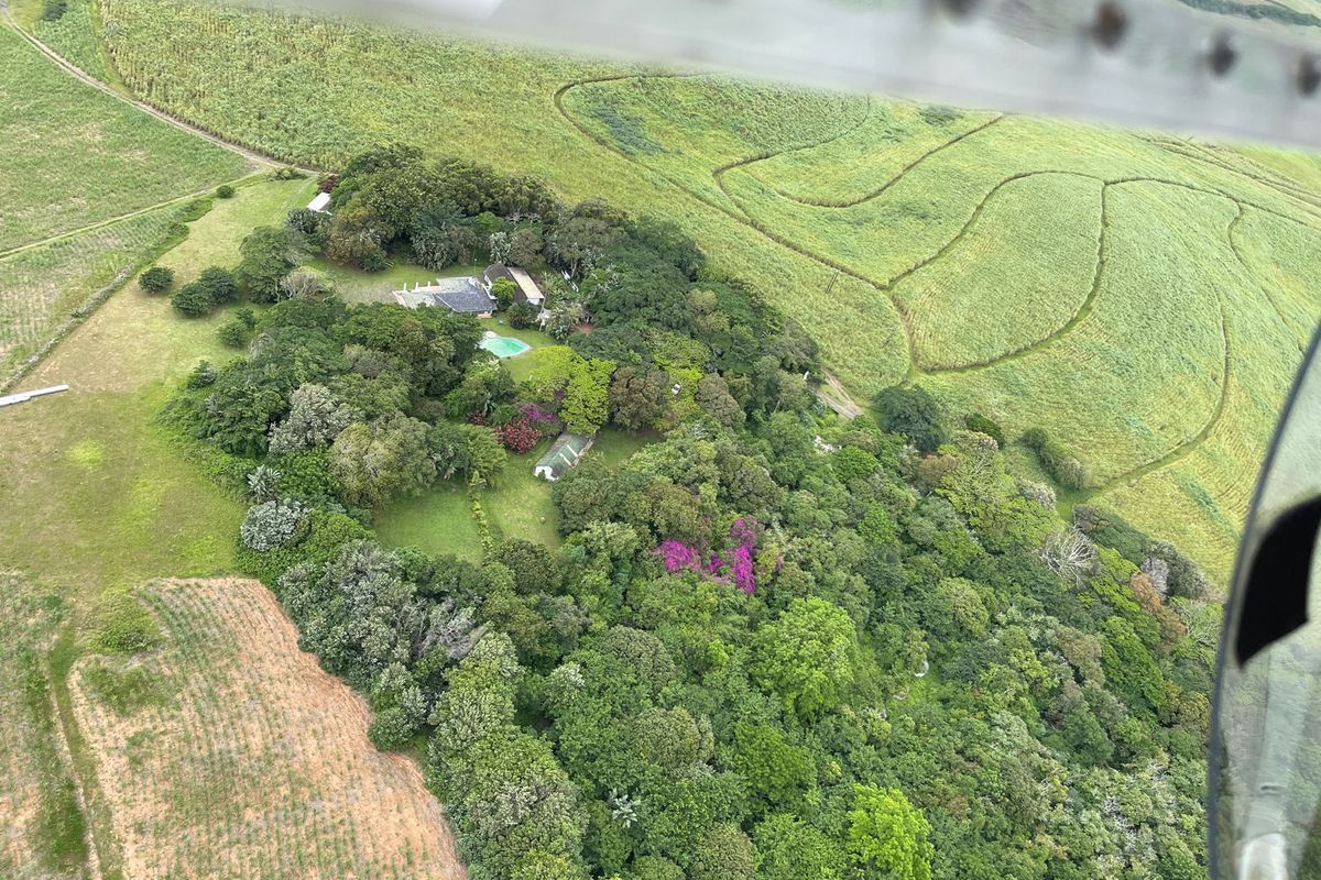 Aerial view of the lodge property, featuring a swimming pool and extensive surrounding gardens set within a rural landscape.