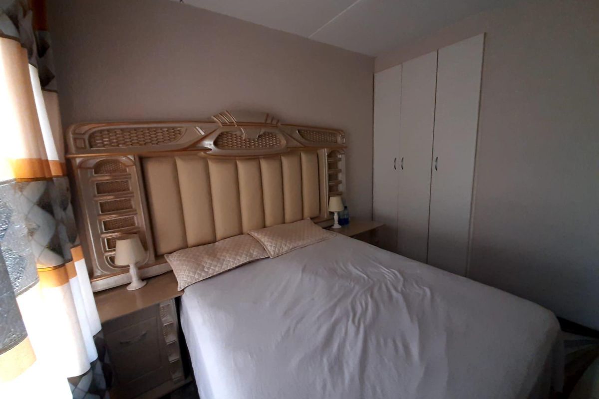 A bedroom featuring built-in white cabinetry and neutral wall finishes, providing a functional and tidy sleeping space.
