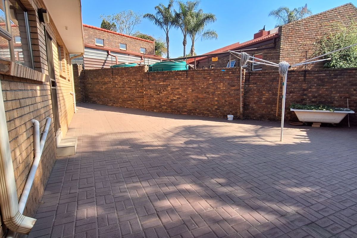 A private rear courtyard featuring paved flooring and high brick boundary walls, providing a secure and low-maintenance outdoor space.