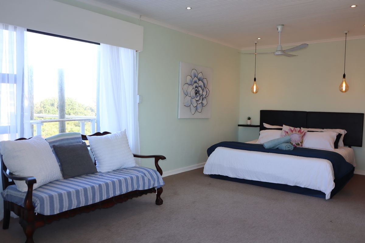 Spacious bedroom featuring a ceiling fan, recessed lighting, and a large sliding glass door providing natural light and access to an outdoor area.