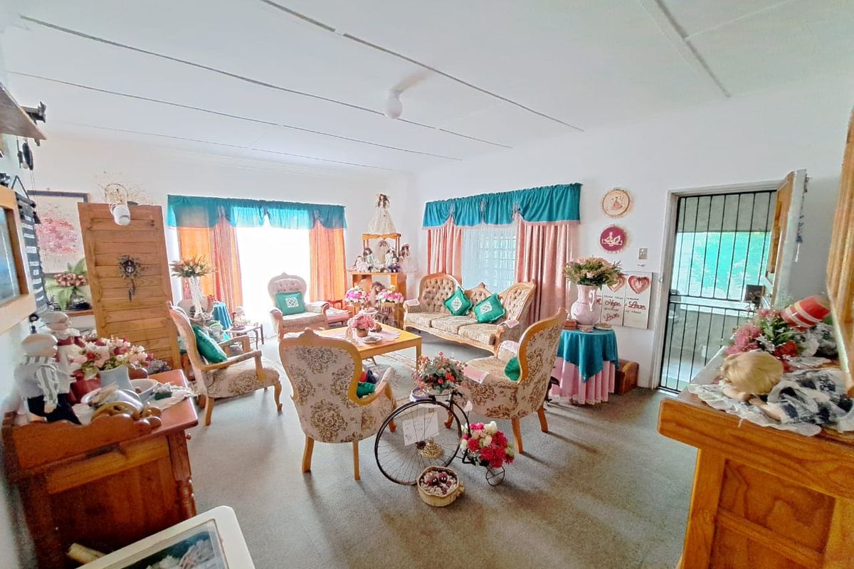 A spacious living room featuring a security gate entrance and a tiled ceiling, offering a functional layout for comfortable family living.