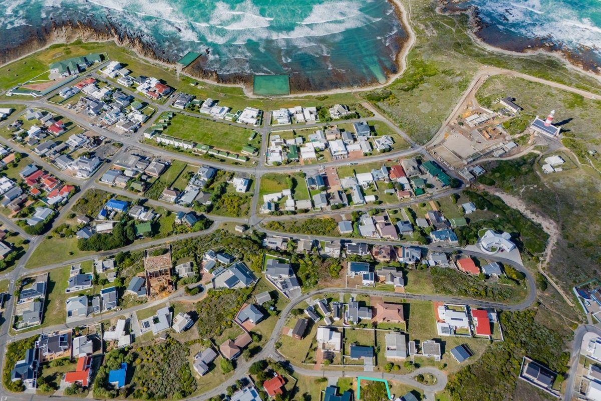 An aerial view of a coastal residential neighborhood, showcasing the layout of properties, road networks, and proximity to the ocean.