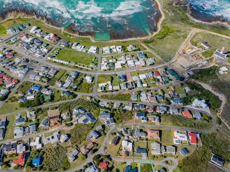 An aerial view of a coastal residential neighborhood, showcasing the layout of properties, road networks, and proximity to the ocean.