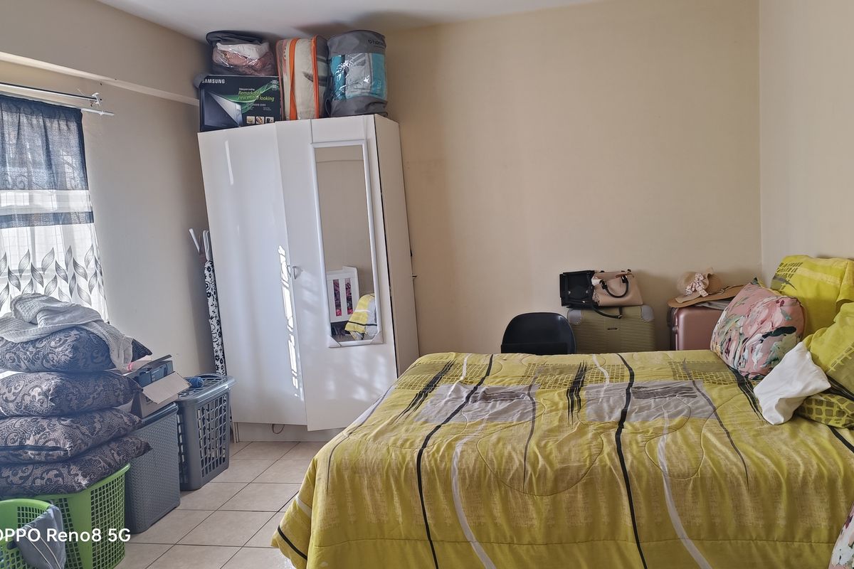 A bedroom featuring tiled flooring and a built-in wardrobe, offering a functional space ready for personalization.