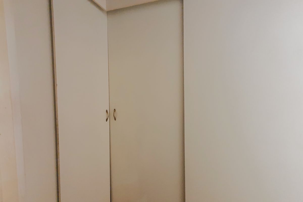 A close-up view of built-in bedroom cupboards with simple handles.