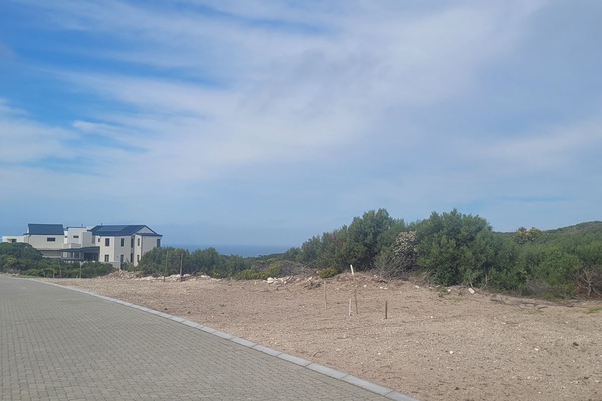A view of the paved street frontage and surrounding coastal landscape, showcasing the vacant residential land and local neighbourhood setting.
