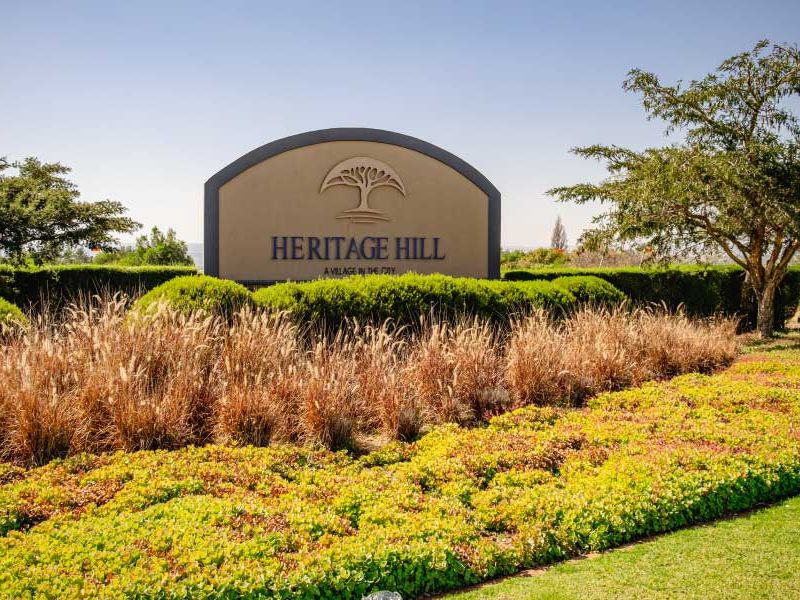 A well-maintained entrance sign and landscaped garden area for the Heritage Hill estate.