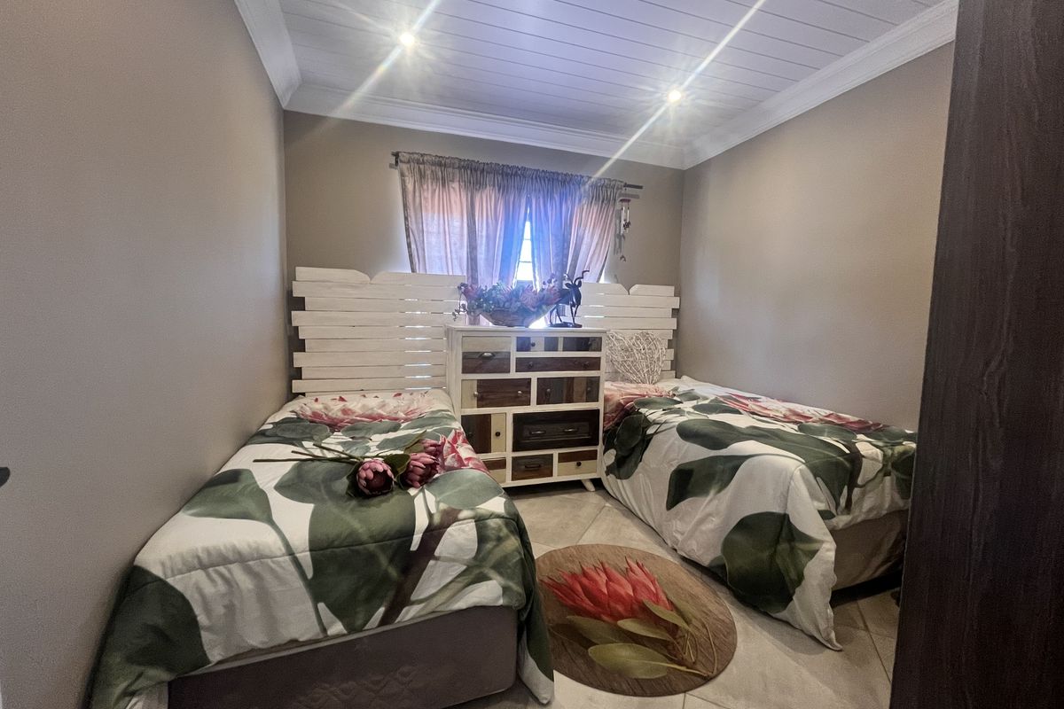 A cozy bedroom featuring tiled flooring, a white tongue and groove ceiling with recessed lighting, and crown molding details.