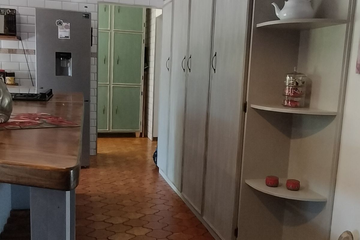 Kitchen area featuring extensive built-in cabinetry, a central island, and distinctive tiled flooring with a subway tile backsplash.