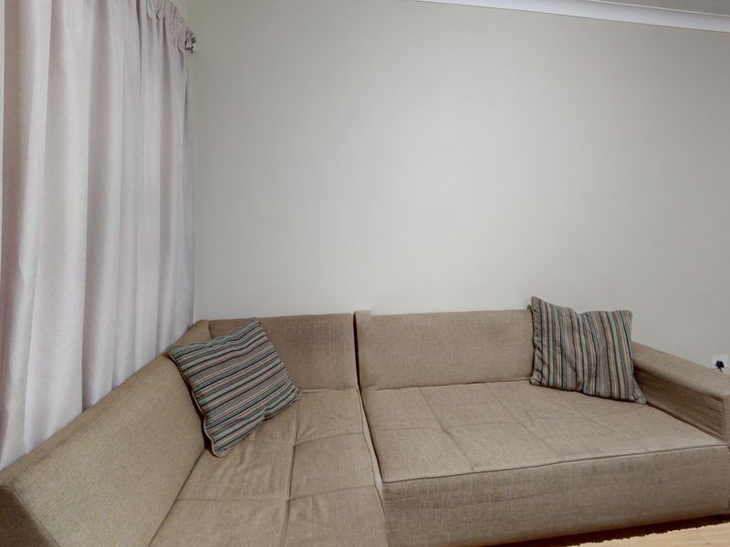 A living room area featuring neutral wall finishes and curtain tracks, providing a blank canvas for interior design updates.