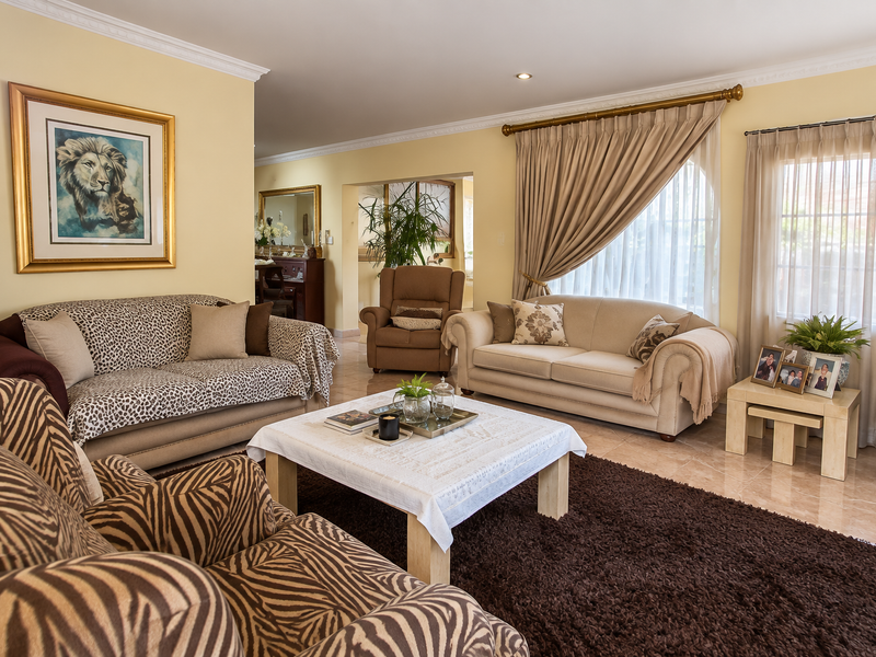 A well-maintained living room featuring tiled flooring, crown molding, and recessed lighting, offering a comfortable and inviting space for relaxation.