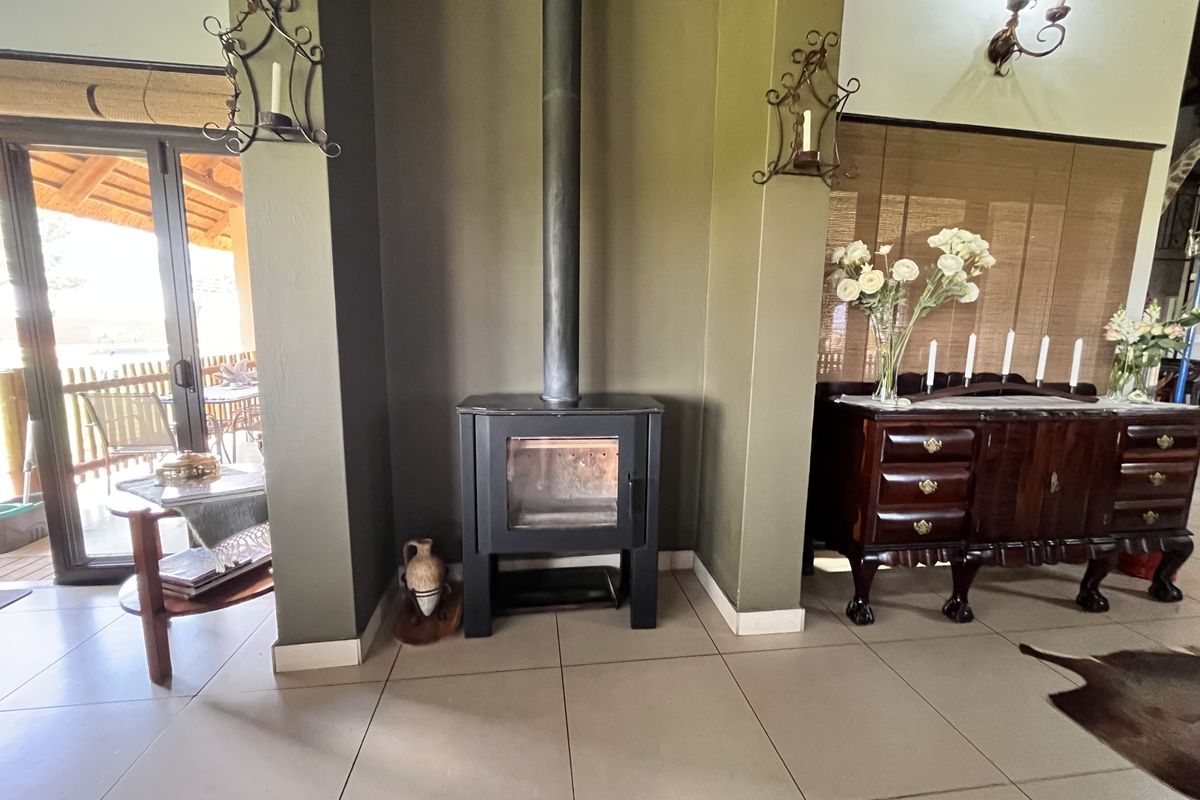 A cozy living area featuring a central freestanding fireplace, tiled flooring, and a sliding glass door providing access to the outdoor patio.