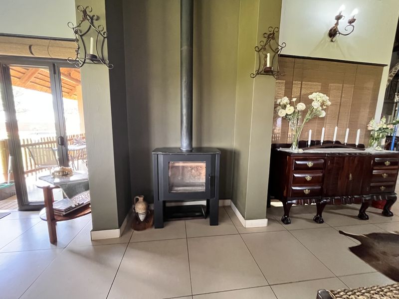 A cozy living area featuring a central freestanding fireplace, tiled flooring, and a sliding glass door providing access to the outdoor patio.