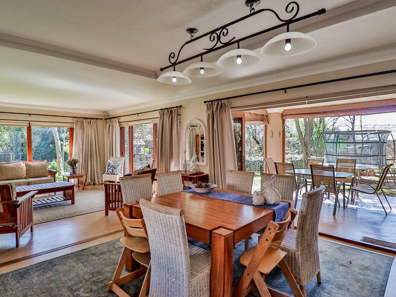 Spacious open-plan living and dining area featuring large sliding glass doors that provide seamless access to the outdoor patio and garden.
