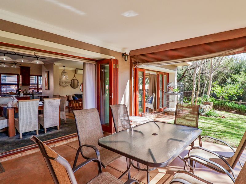 Covered patio area featuring tiled flooring and bi-fold doors that provide seamless indoor-outdoor flow to the garden.