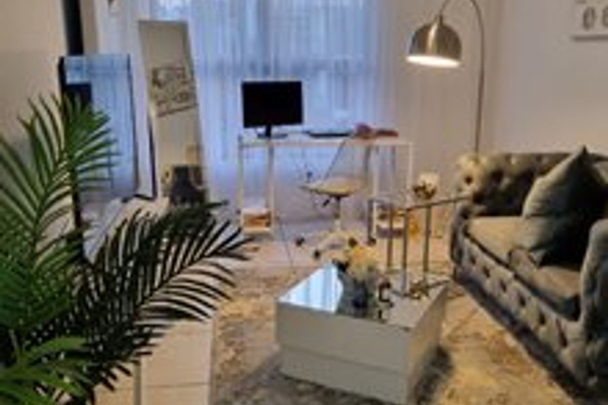 A compact living room featuring tiled flooring and a large window, providing a functional space for relaxation and home office use.