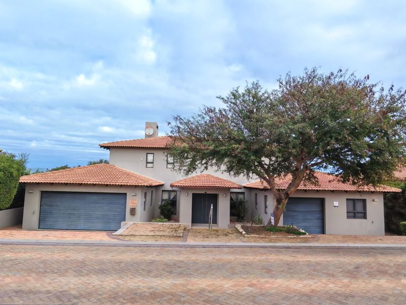 Front elevation of a two-story residential property featuring a double garage, terracotta tiled roof, and paved driveway access.