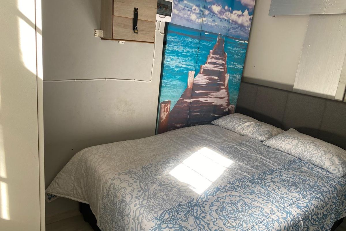 A bedroom featuring an exposed electrical distribution board and wall-mounted wiring, requiring cosmetic updates to improve the overall finish and aesthetic appeal.