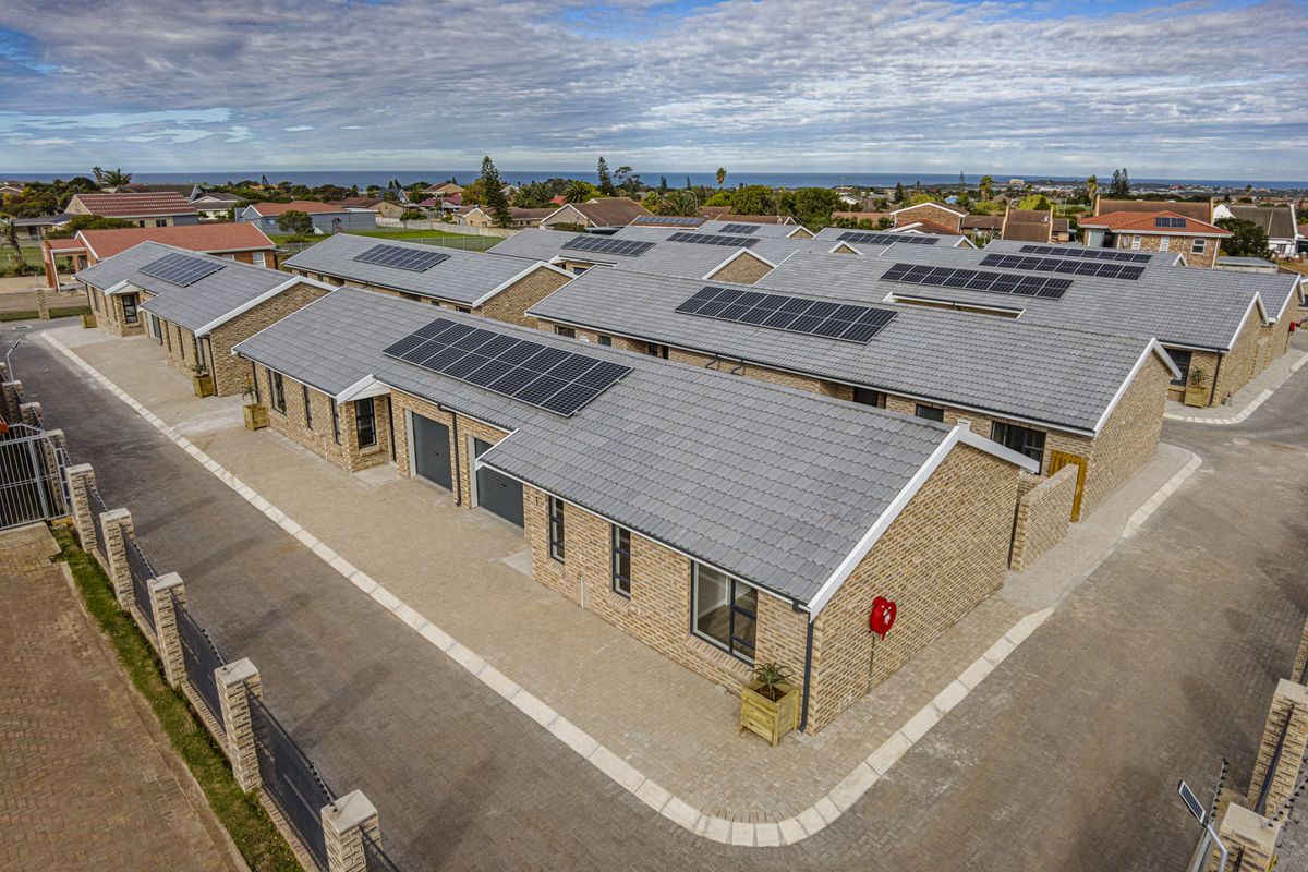 Aerial view of a modern townhouse complex featuring brick facades, tiled roofs, and integrated solar panel installations.