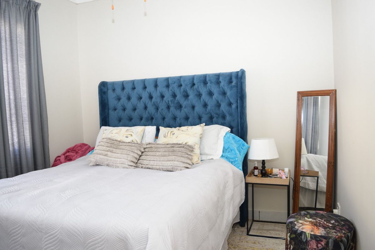 A standard bedroom featuring neutral wall finishes and a curtain rail, providing a functional and comfortable sleeping space.