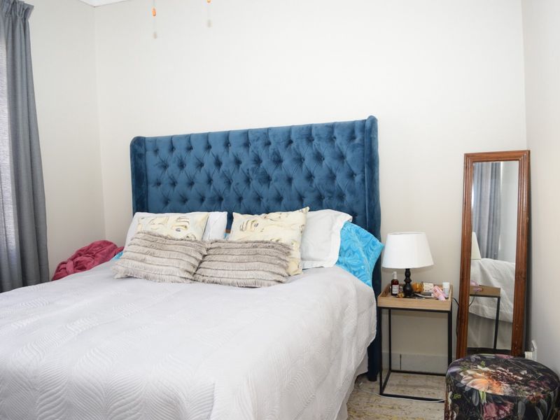 A standard bedroom featuring neutral wall finishes and a curtain rail, providing a functional and comfortable sleeping space.