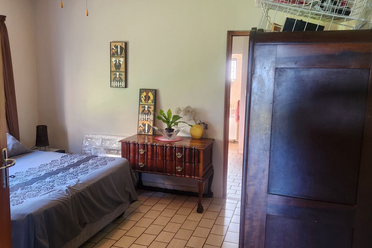 A bedroom featuring tiled flooring and direct access to an adjoining bathroom area.