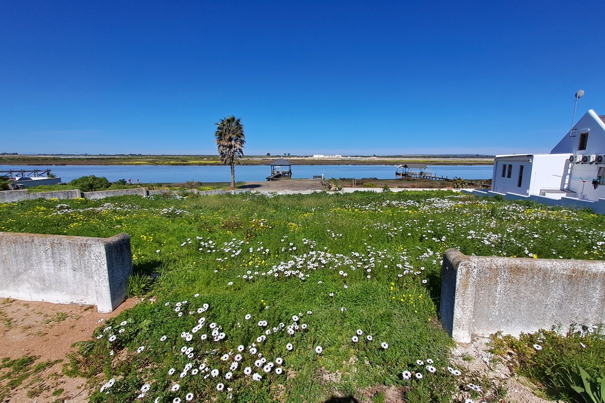 Vacant residential land featuring concrete boundary walls and direct waterfront access with scenic views.