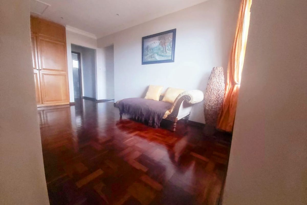 A bedroom featuring polished parquet flooring and built-in wooden cupboards, offering a classic foundation for interior design updates.