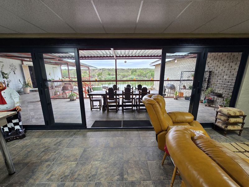 Open plan living area featuring large sliding glass doors that open onto a covered patio with scenic water views.