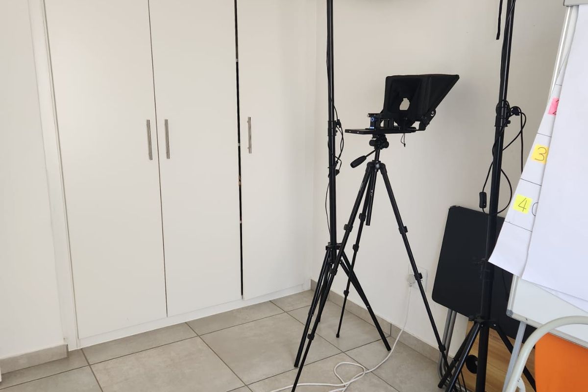 A bedroom featuring neutral tiled flooring and a white built-in wardrobe with modern handles.