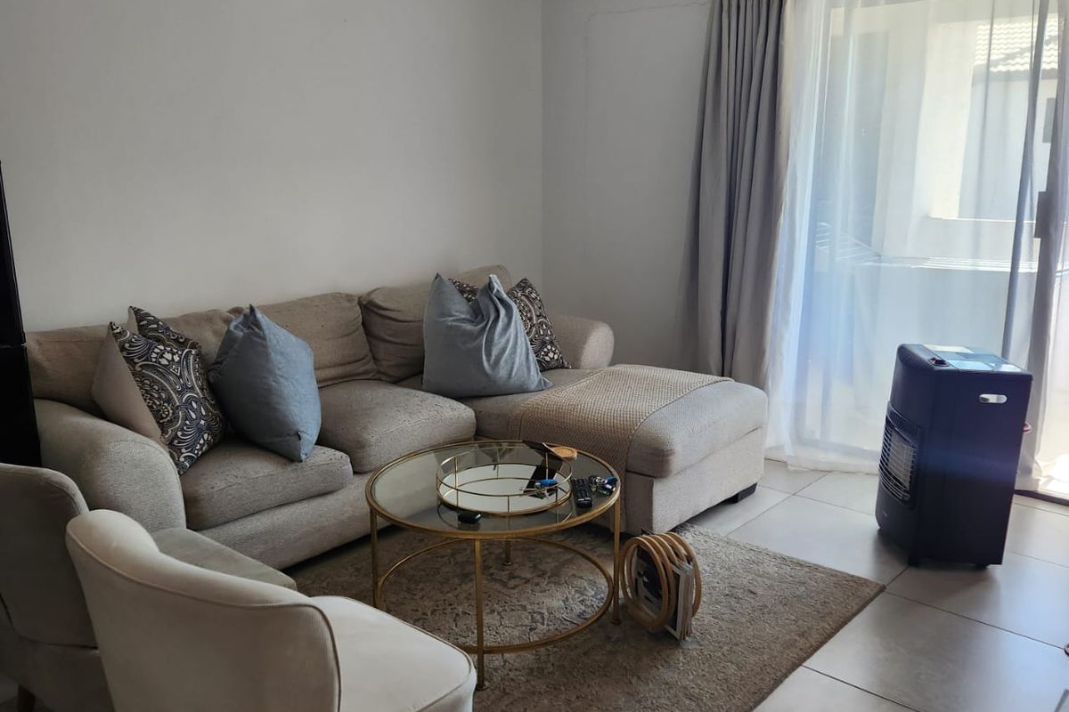 A living room featuring tiled flooring and a sliding glass door providing access to an outdoor area.