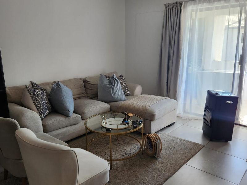 A living room featuring tiled flooring and a sliding glass door providing access to an outdoor area.