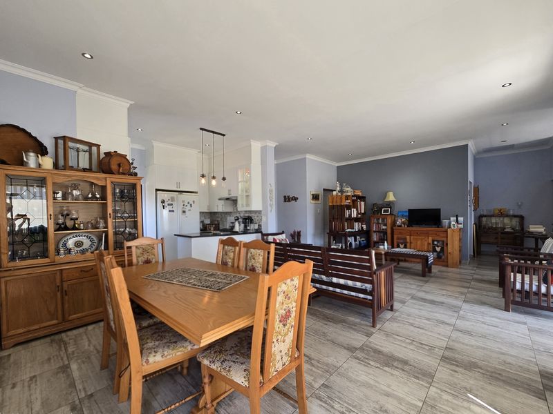 Spacious open-plan living area featuring tiled floors, recessed lighting, and a functional kitchen with built-in cabinetry and an island.