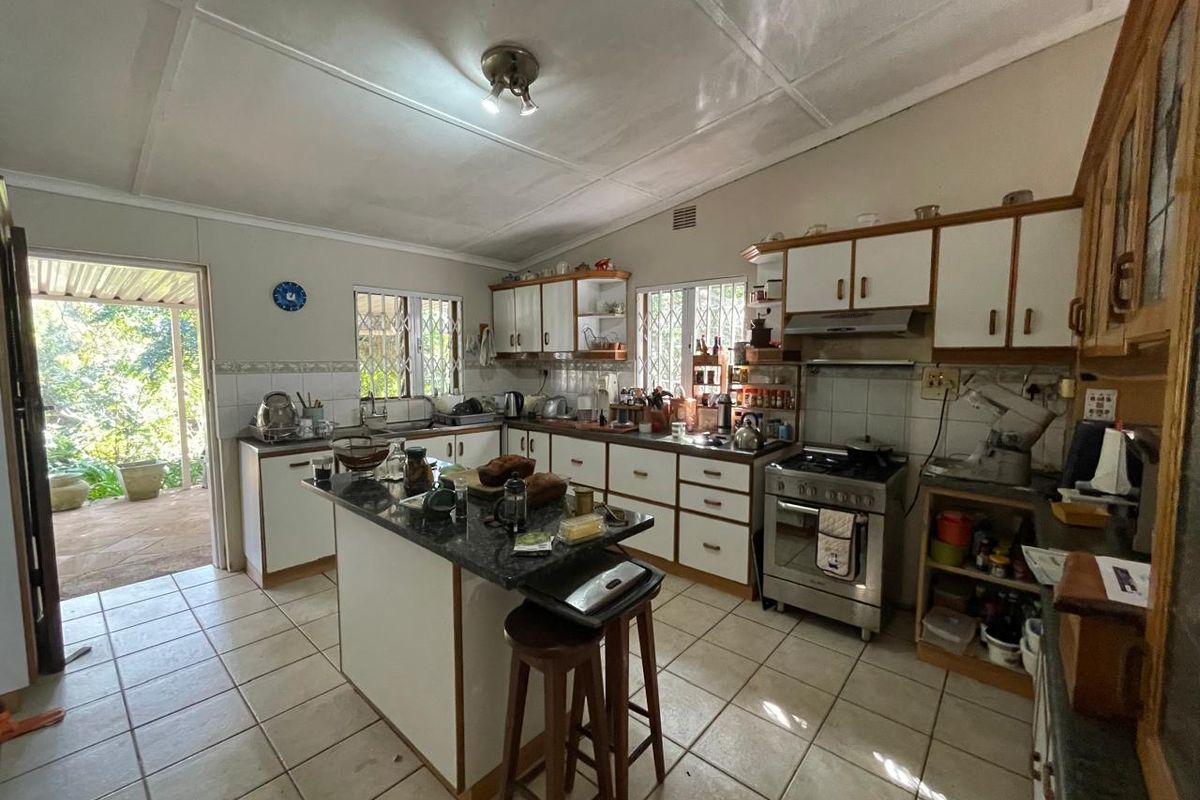 A functional kitchen featuring a central island, granite countertops, gas stove, and direct access to an outdoor patio area.