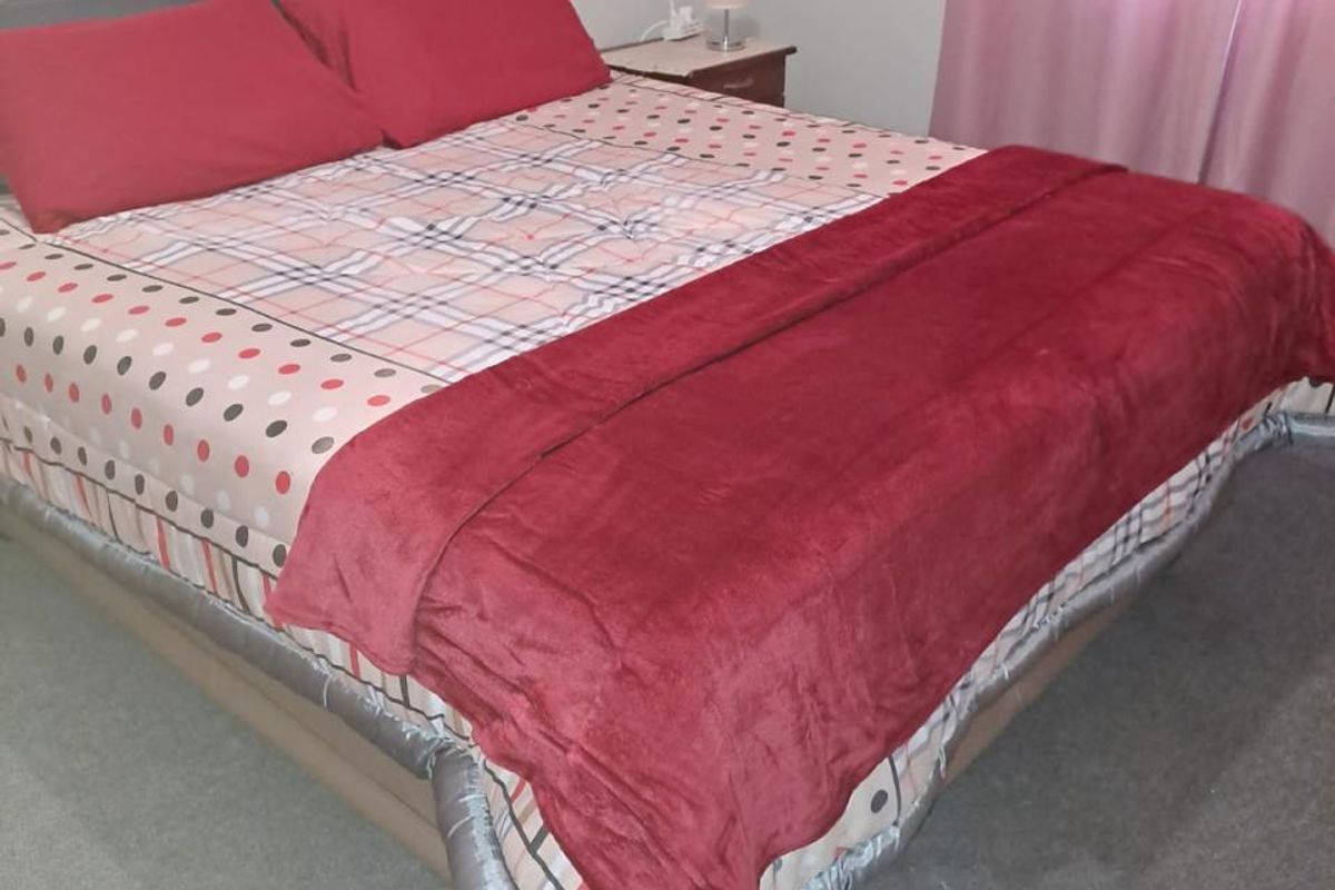 A standard bedroom featuring neutral wall finishes and carpeted flooring.